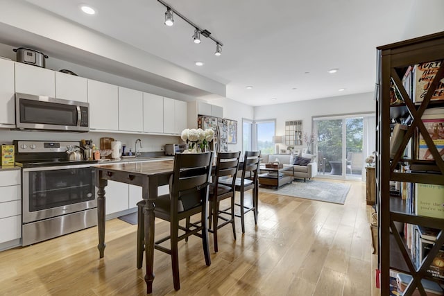 400 Herron Dr Unit 107, Nashville, TN 37210 - kitchen featuring appliances with stainless steel finishes, light wood-style floors, white cabinetry, modern cabinets, and open floor plan