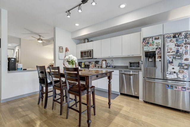 400 Herron Dr Unit 107, Nashville, TN 37210 - kitchen with stainless steel appliances, ceiling fan, light wood-style floors, white cabinets, and a sink
