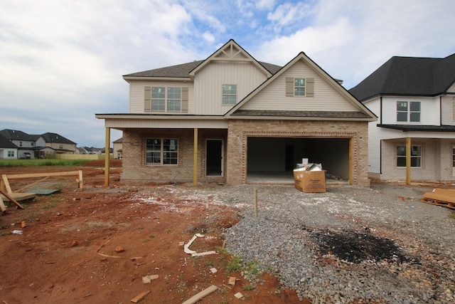 view of front of property featuring brick siding, covered porch, a garage, and board and batten siding