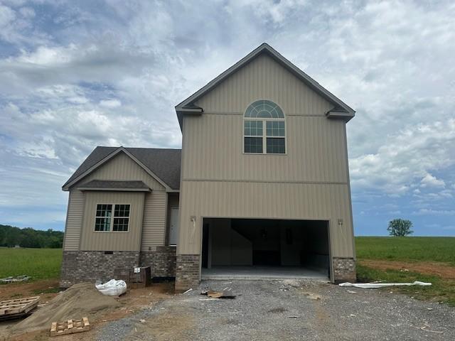 view of front facade featuring dirt driveway and an attached garage