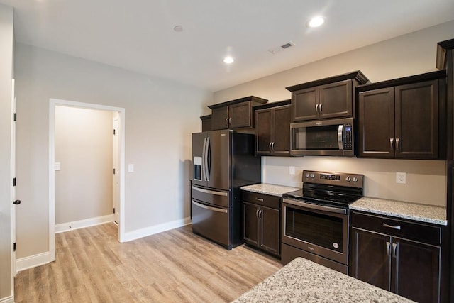 kitchen featuring appliances with stainless steel finishes, light wood-type flooring, dark brown cabinetry, baseboards, and light stone countertops
