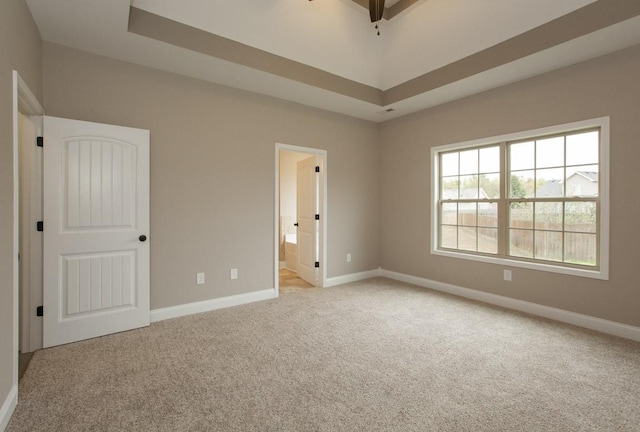 unfurnished bedroom with light colored carpet, baseboards, and ensuite bath