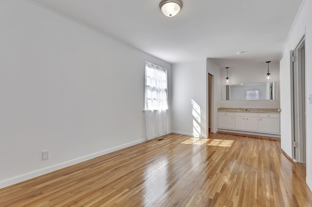 spare room featuring light wood-style flooring and baseboards