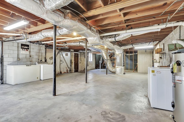 unfinished basement featuring water heater, washing machine and clothes dryer, and fridge