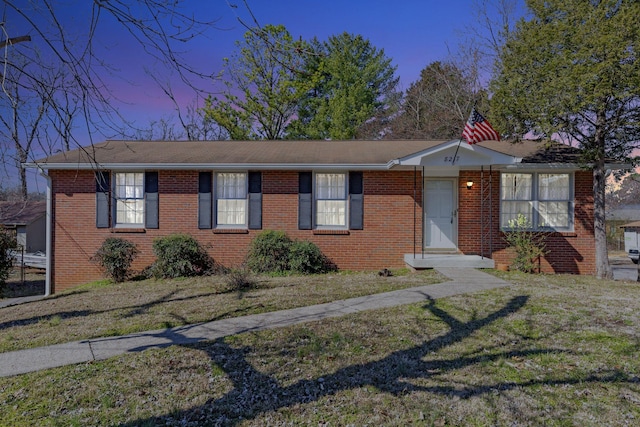 ranch-style house with brick siding and a front yard