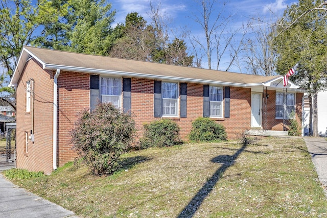 ranch-style home featuring brick siding and a front lawn