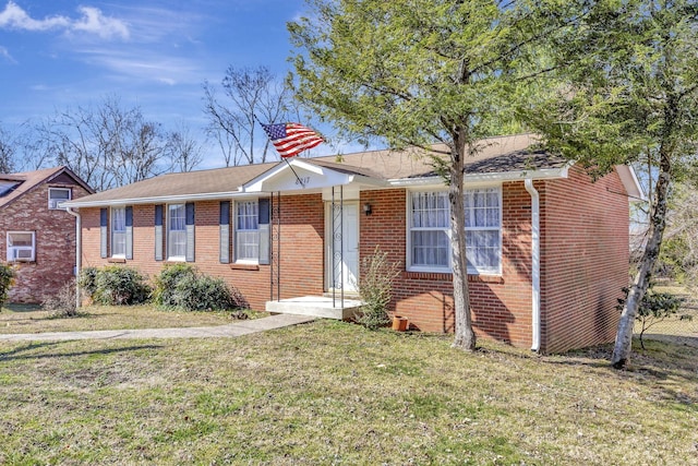 view of front of home featuring a front lawn, brick siding, and roof with shingles