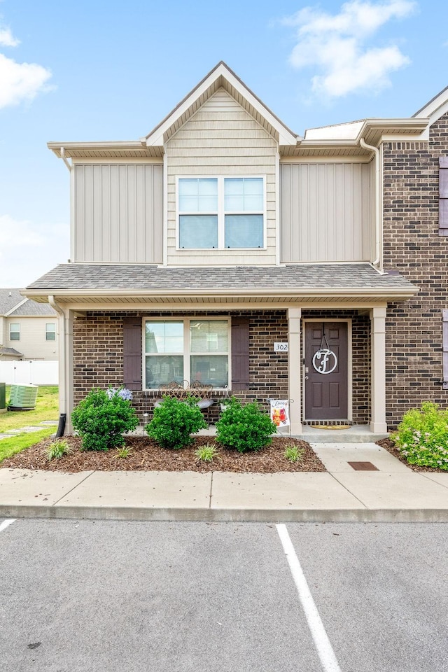 multi unit property featuring brick siding, uncovered parking, and board and batten siding