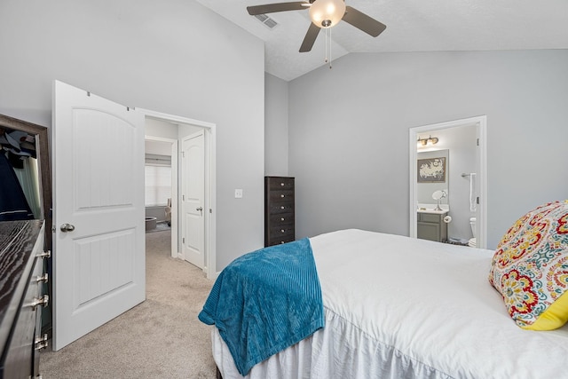 bedroom with light colored carpet, vaulted ceiling, ensuite bathroom, and a ceiling fan