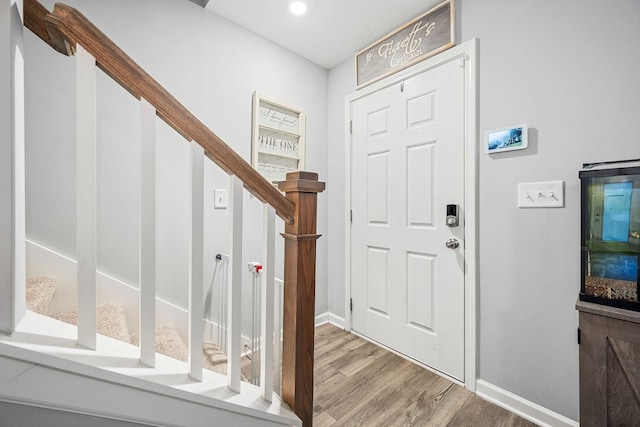 entrance foyer with baseboards, wood finished floors, stairway, and recessed lighting