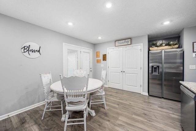 dining room featuring light wood-style floors, baseboards, and recessed lighting
