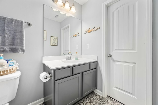 half bath featuring vanity, toilet, and baseboards