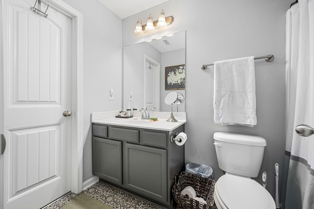full bath with toilet, vanity, and baseboards