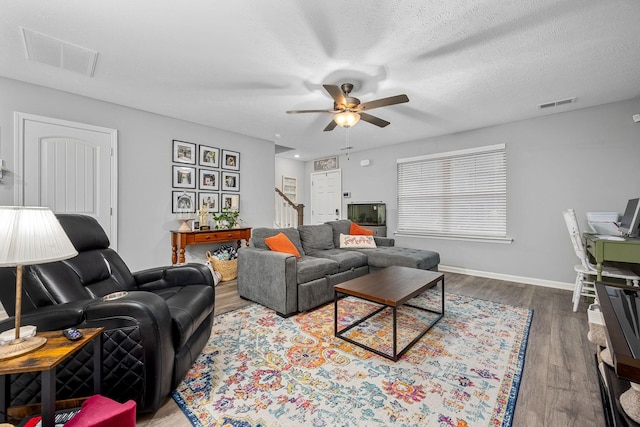 living area with ceiling fan, stairs, wood finished floors, and baseboards