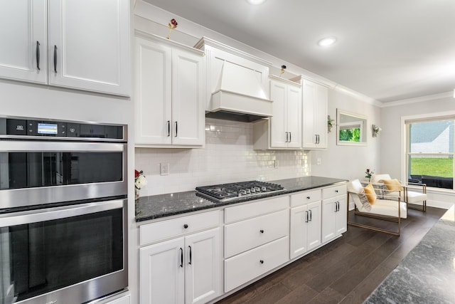 1149 Brixworth Dr, Spring Hill, TN 37174 - kitchen with stainless steel appliances, dark wood-style floors, white cabinetry, dark stone counters, and ornamental molding