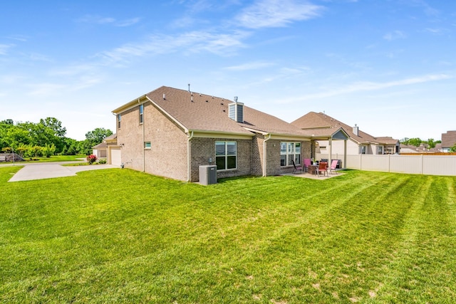 1149 Brixworth Dr, Spring Hill, TN 37174 - rear view of property featuring cooling unit, brick siding, a patio area, concrete driveway, and a chimney