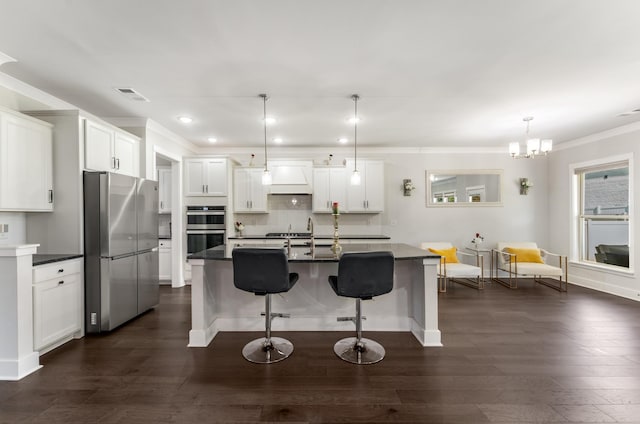 1149 Brixworth Dr, Spring Hill, TN 37174 - kitchen with stainless steel appliances, dark wood-type flooring, dark countertops, a breakfast bar area, and ornamental molding