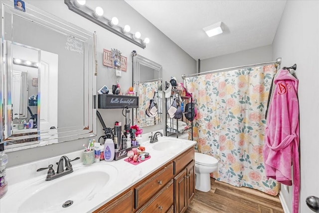890 Akersville Rd, Lafayette, TN 37083 - bathroom featuring wood finished floors, toilet, double vanity, a shower with shower curtain, and a textured ceiling