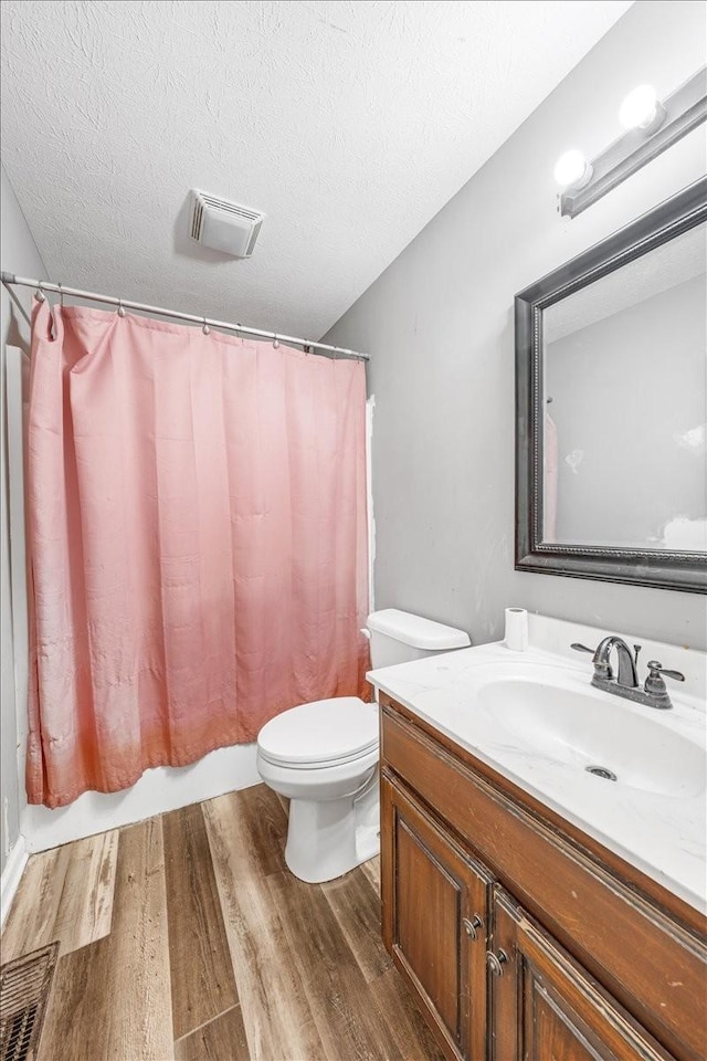 890 Akersville Rd, Lafayette, TN 37083 - full bathroom featuring wood finished floors, toilet, vanity, a textured ceiling, and shower / tub combo with curtain