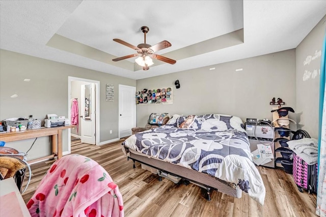 890 Akersville Rd, Lafayette, TN 37083 - bedroom with a tray ceiling, light wood-style flooring, baseboards, and ceiling fan