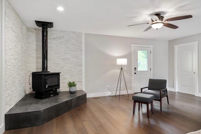 593 Gaulden Hollow Rd, Lafayette, TN 37083 - sitting room featuring a wood stove, a ceiling fan, baseboards, and wood finished floors