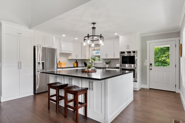 593 Gaulden Hollow Rd, Lafayette, TN 37083 - kitchen with appliances with stainless steel finishes, dark countertops, premium range hood, dark wood finished floors, and white cabinetry