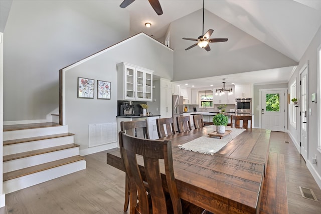 593 Gaulden Hollow Rd, Lafayette, TN 37083 - dining room with a ceiling fan, stairs, a chandelier, wood finished floors, and high vaulted ceiling