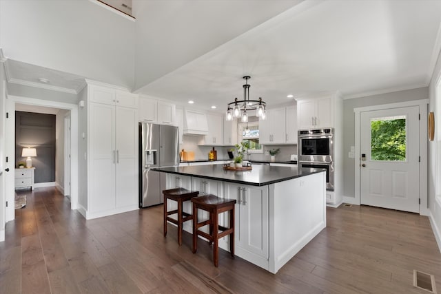 593 Gaulden Hollow Rd, Lafayette, TN 37083 - kitchen with appliances with stainless steel finishes, dark countertops, white cabinetry, healthy amount of natural light, and crown molding