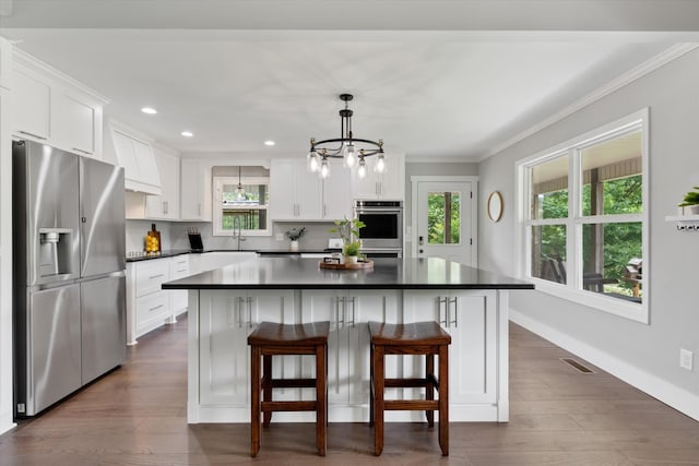 593 Gaulden Hollow Rd, Lafayette, TN 37083 - kitchen featuring appliances with stainless steel finishes, dark countertops, crown molding, white cabinetry, and plenty of natural light
