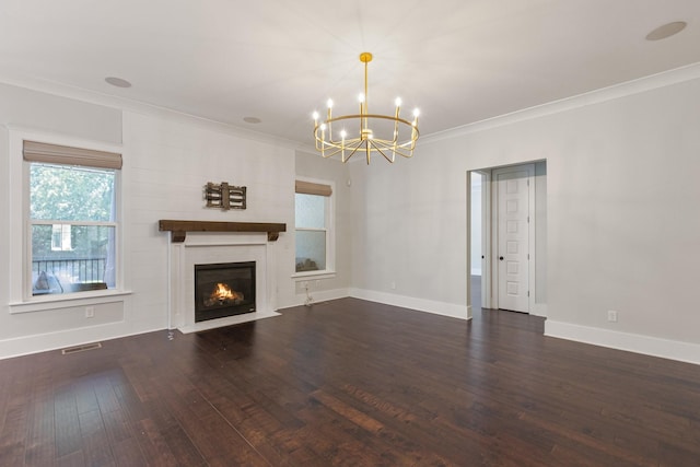 unfurnished living room with a chandelier, crown molding, baseboards, wood finished floors, and a fireplace with flush hearth