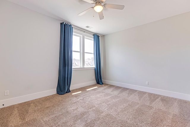 spare room with light carpet, a ceiling fan, and baseboards