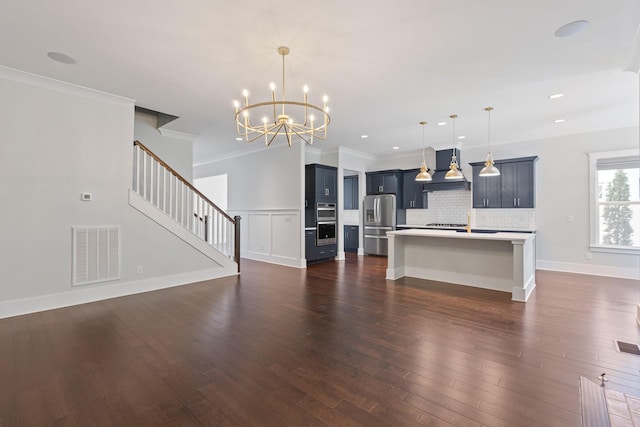unfurnished living room with a chandelier, dark wood-style floors, crown molding, recessed lighting, and stairs