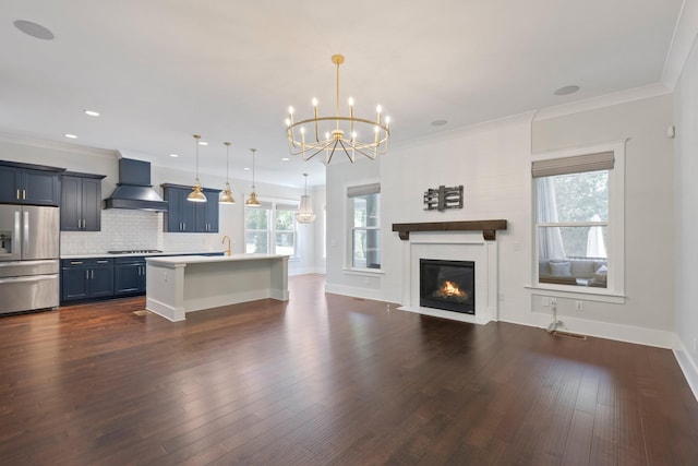 unfurnished living room featuring a chandelier, a glass covered fireplace, dark wood-style flooring, ornamental molding, and baseboards