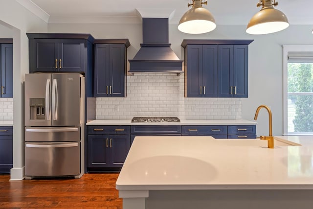 kitchen with stainless steel appliances, premium range hood, light countertops, blue cabinets, and dark wood-style flooring