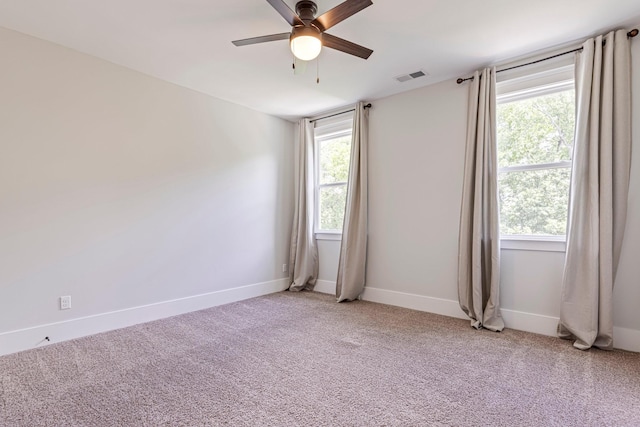 unfurnished room featuring ceiling fan, plenty of natural light, light carpet, and baseboards