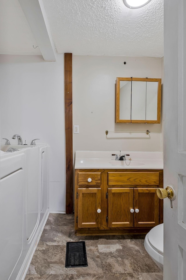 159 Clover St, Granville, TN 38564 - full bathroom featuring washer / clothes dryer, vanity, a textured ceiling, toilet, and a bath