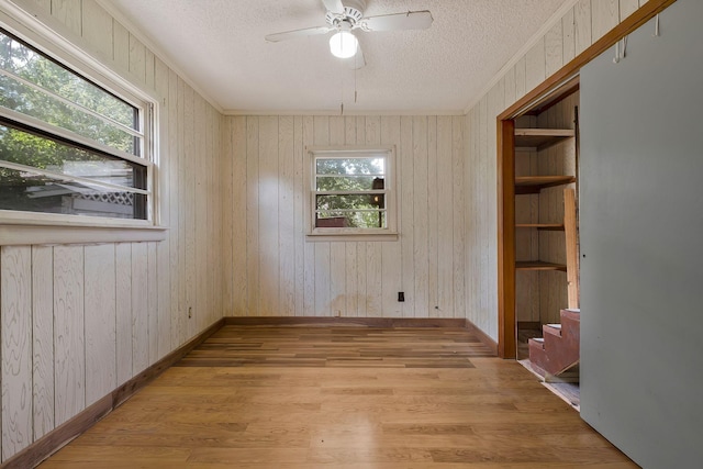 159 Clover St, Granville, TN 38564 - spare room featuring a textured ceiling, light wood-style flooring, a ceiling fan, wood walls, and baseboards