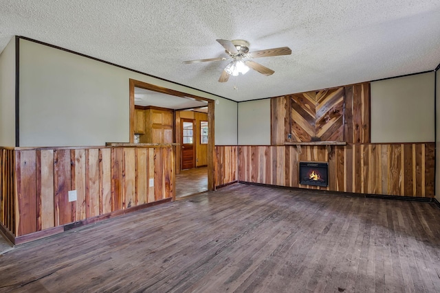 159 Clover St, Granville, TN 38564 - empty room featuring wood-type flooring, a wainscoted wall, a textured ceiling, wood walls, and a ceiling fan