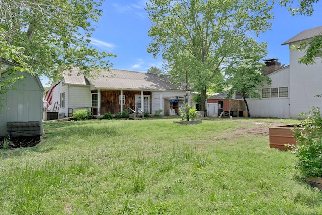 159 Clover St, Granville, TN 38564 - back of property featuring metal roof, a lawn, a vegetable garden, and cooling unit