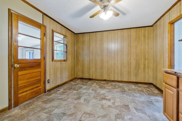 159 Clover St, Granville, TN 38564 - empty room featuring ornamental molding, a textured ceiling, baseboards, wooden walls, and a ceiling fan