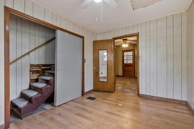 159 Clover St, Granville, TN 38564 - empty room with a ceiling fan, a textured ceiling, wood finished floors, wooden walls, and crown molding