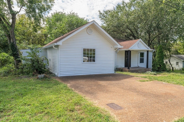 ranch-style home featuring concrete driveway, a porch, and a front yard