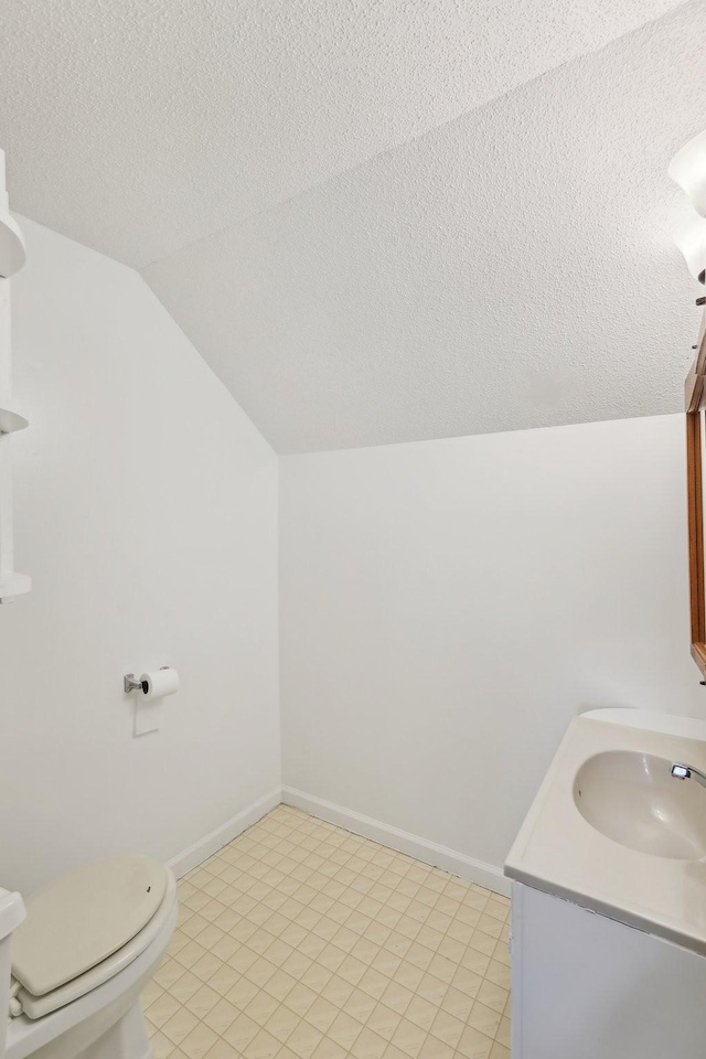 111 Lois Ln, Clarksville, TN 37043 - bathroom with vaulted ceiling, a textured ceiling, vanity, toilet, and baseboards