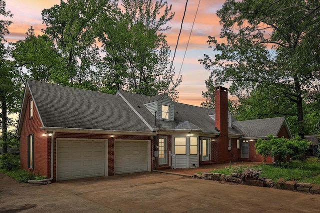 111 Lois Ln, Clarksville, TN 37043 - cape cod house featuring brick siding, a chimney, an attached garage, driveway, and a shingled roof