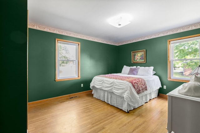 bedroom with light wood-style floors and baseboards