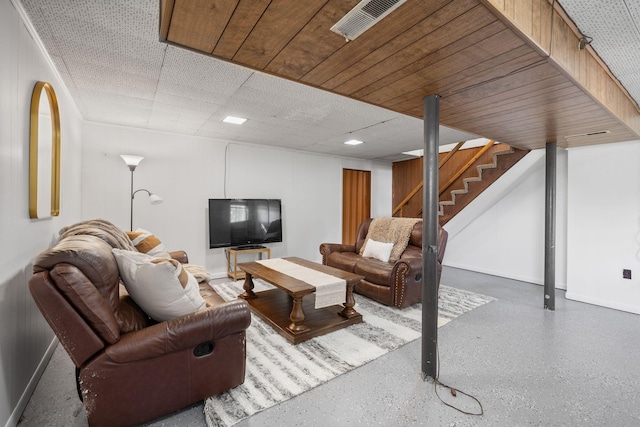 living area with stairs, baseboards, and speckle patterned floor