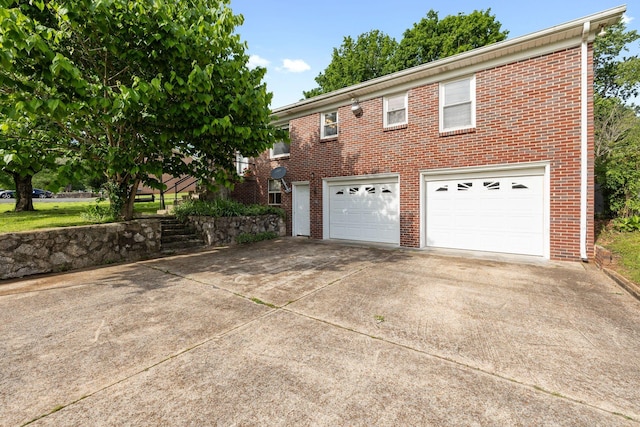 view of front of house featuring concrete driveway, brick siding, and an attached garage