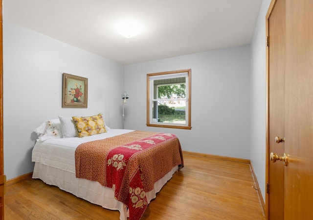 bedroom featuring light wood-style floors and baseboards