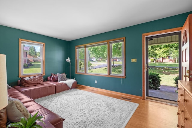 living area with light wood-type flooring and baseboards