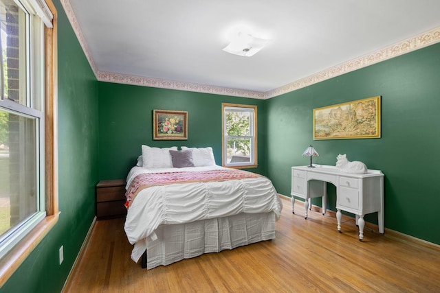 bedroom featuring wood finished floors and baseboards
